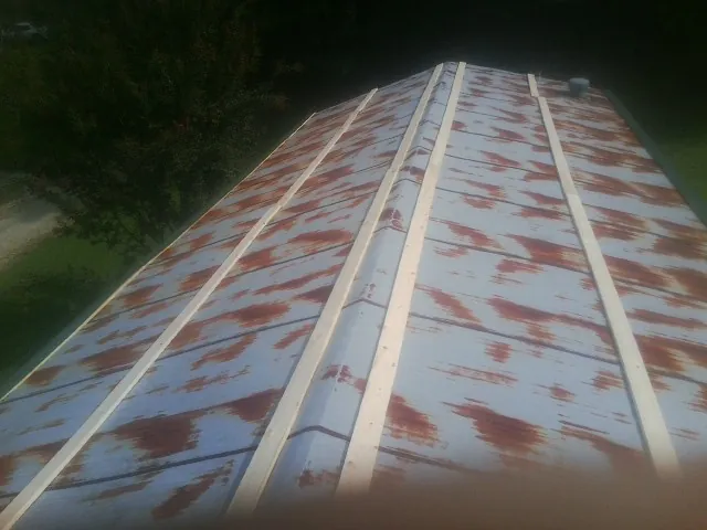 Rusted metal roof panels with new wood purlins before replacement — Storm Damage Roof Repair in Bessemer by Roofing Brothers